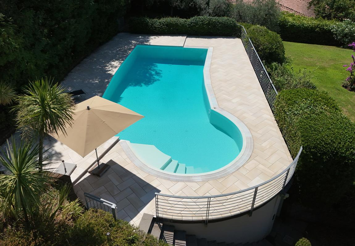 The pool with its curved shallow end and parasol