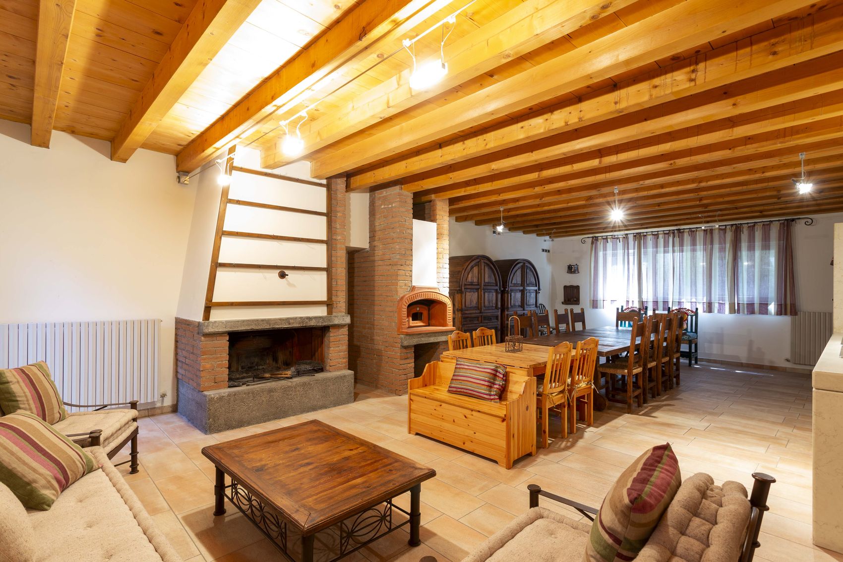 The lounge end of the taverna with sofas around an open fireplace